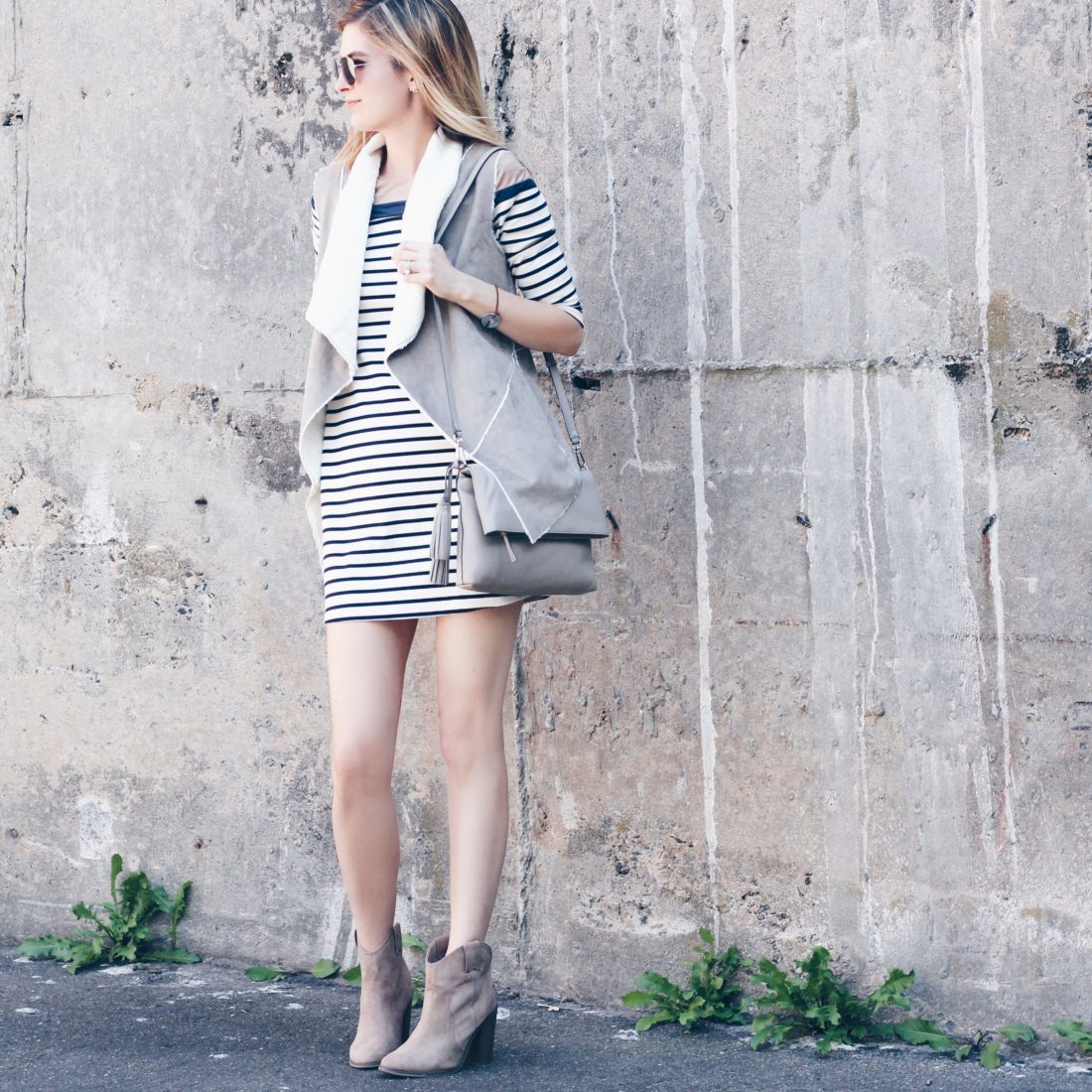 fall outfit: shearling vest over striped dress with tan booties