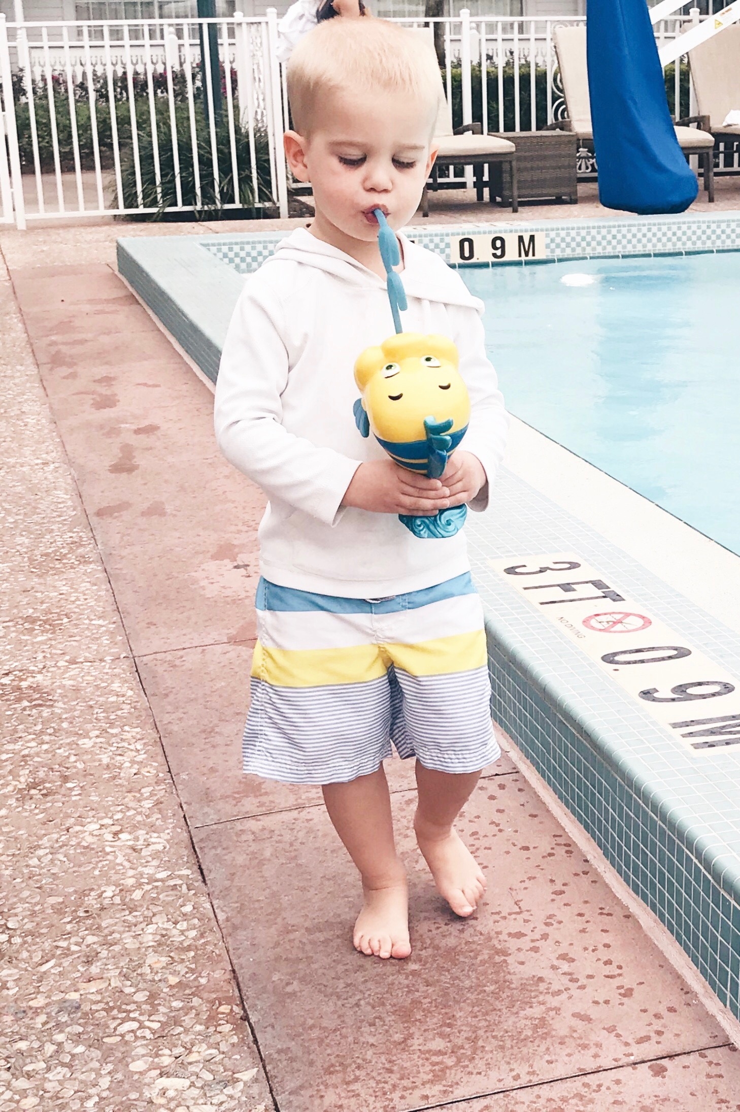 little mermaid pool party - toddler boy drinking from flounder drink cup