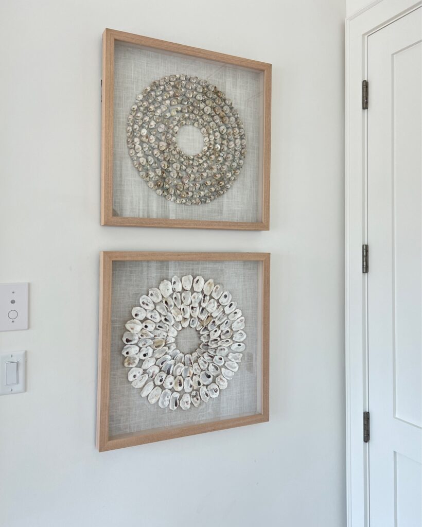 Framed trochidae shell shadow wall art from Pottery Barn in a coastal home, adding texture and natural elements to a capsule home decor collection. A stylish way to incorporate organic materials into modern interiors.