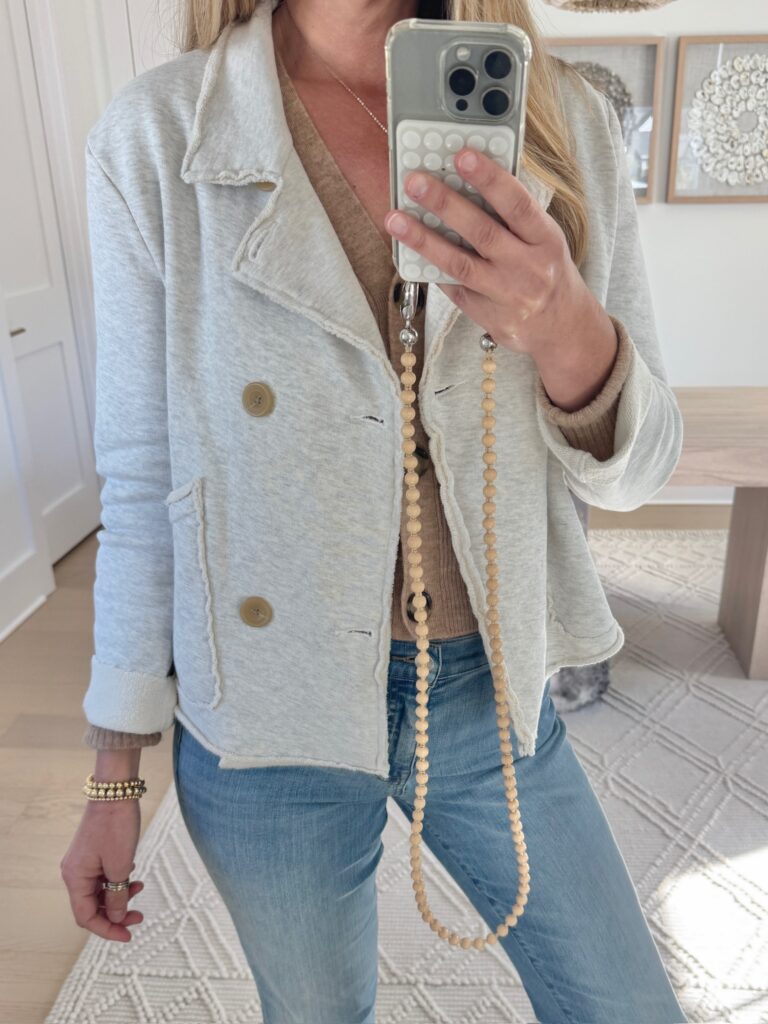 Casual chic outfit featuring a Frank and Eileen soft gray Mini Belfast Sweatshirt Blazer and light-wash denim. Styled with a trendy Ossa wood bead phone strap for an effortlessly polished look.